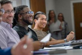 Smiling students around table in seminary classroom